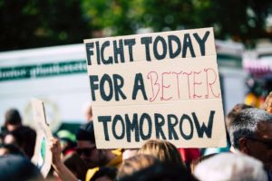 people at a rally with the sign "fight for a better tomorrow"