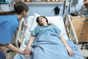 Nurse helping patient in hospital bed